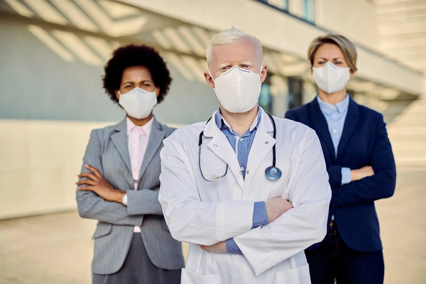 Masked medical team standing confidently outdoors