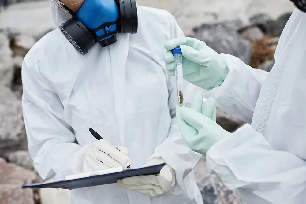 Scientists in hazmat suits collecting environmental sample